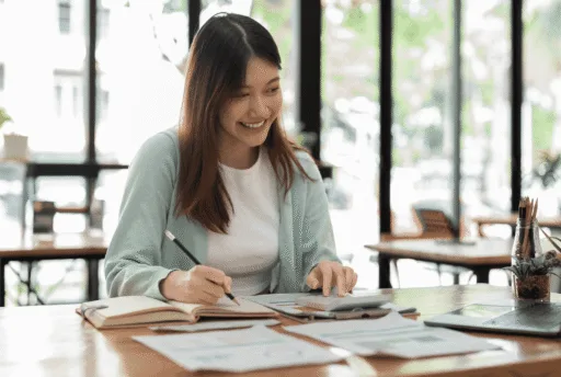 A woman smiling while writing