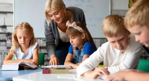 Teacher helping primary school students in a small group class