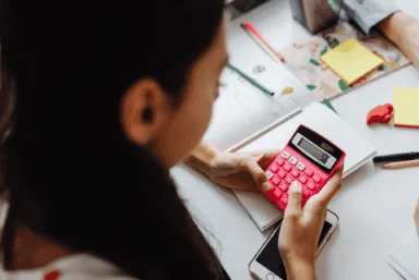 A student using a calculator for a VCE General Maths exam question.